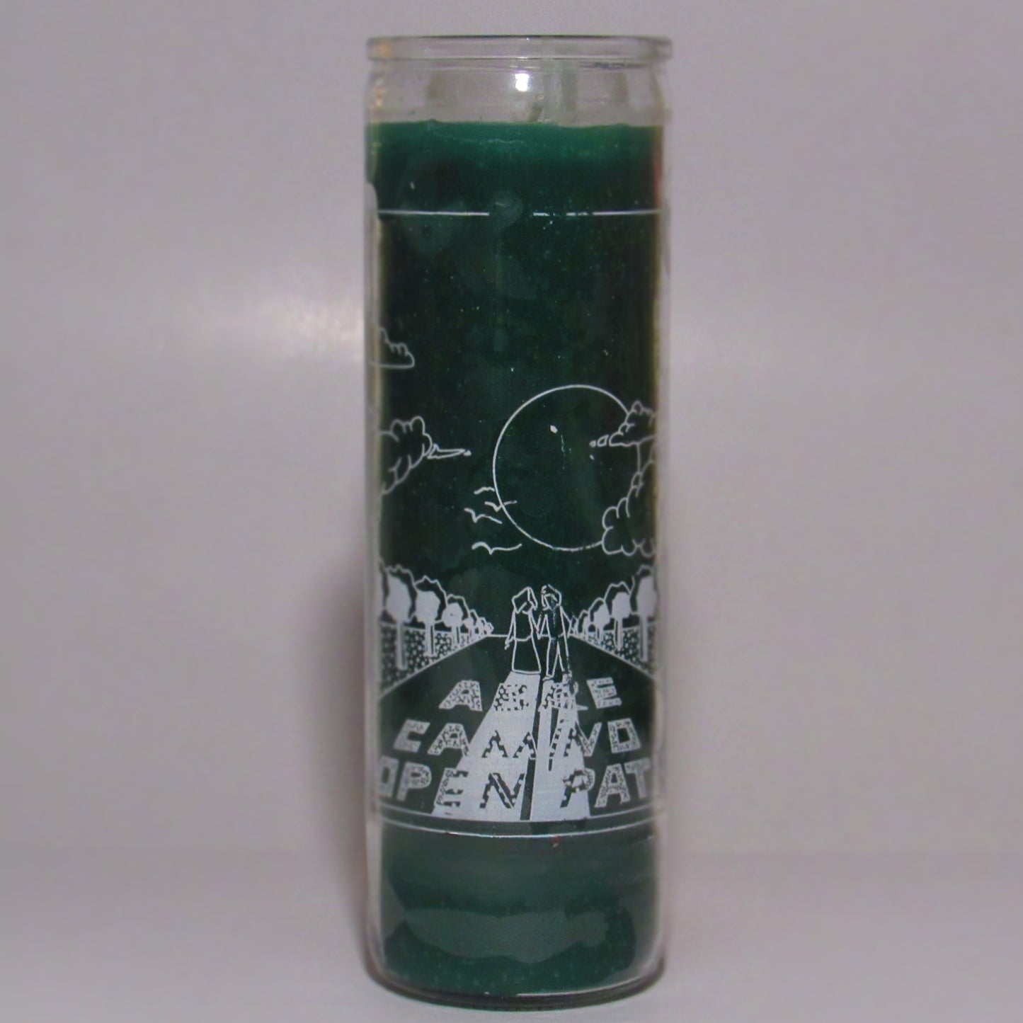 Green candle with white designs and text