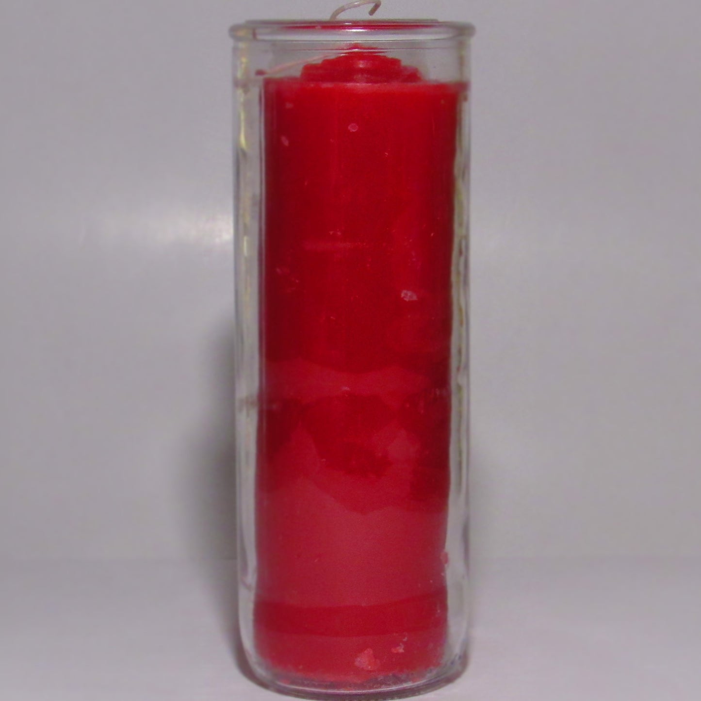 Red candle in a clear glass holder o