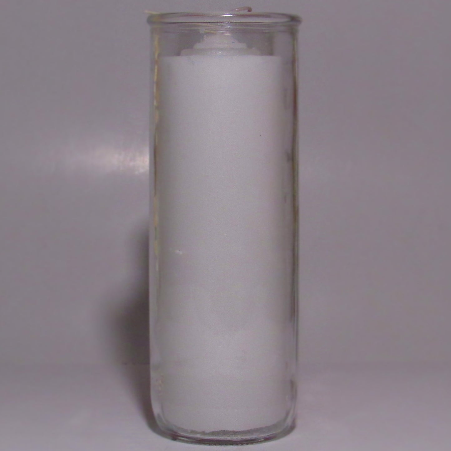 Clear glass candle holder with a white candle