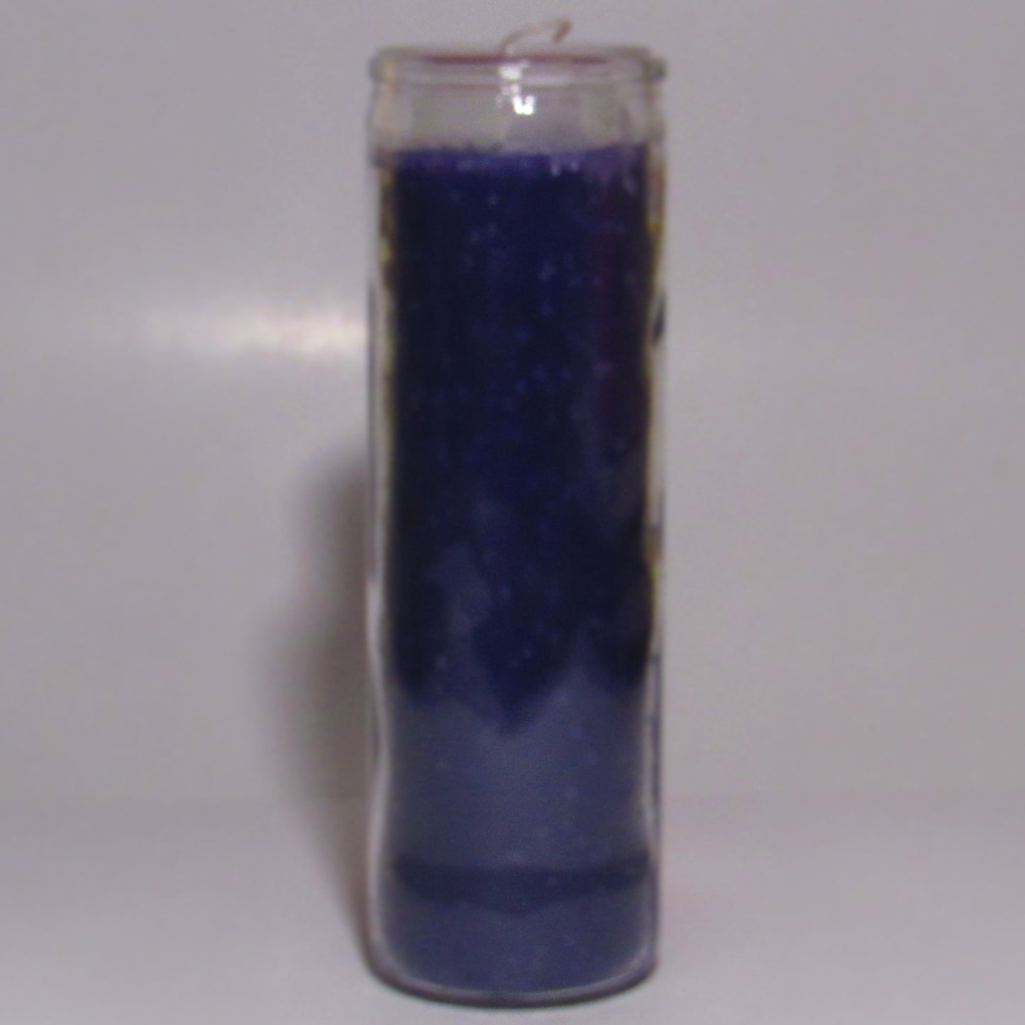 Purple candle in a glass holder