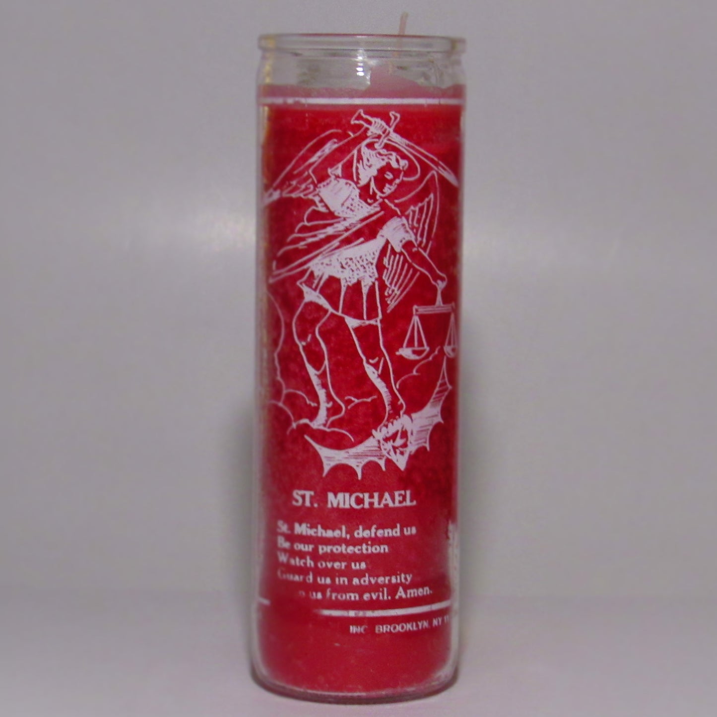 Red candle with white graphics and text