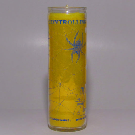 Yellow candle with spider design and text 