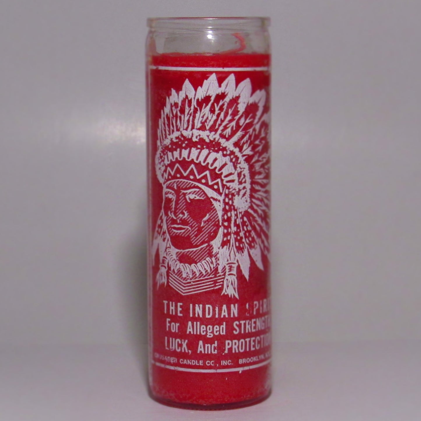 Red candle with white graphics and text