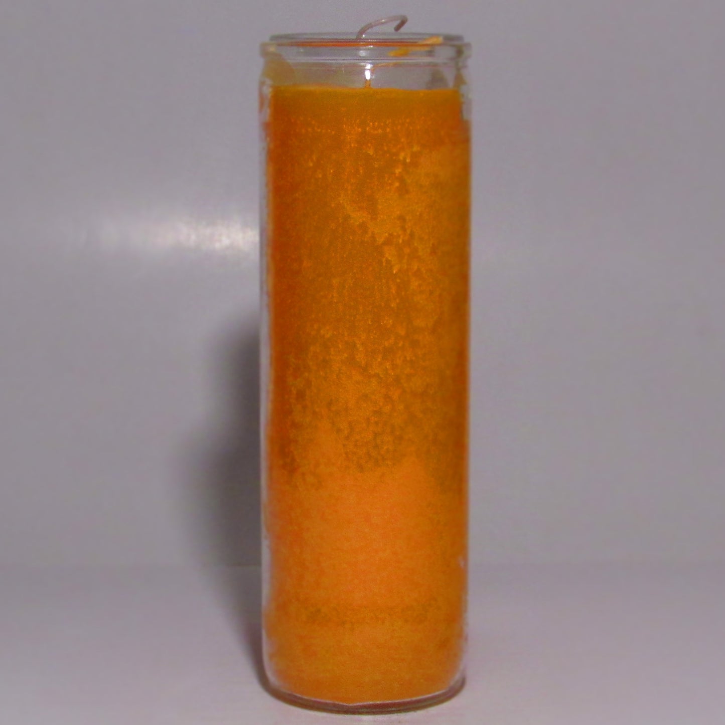 Orange candle in a glass jar on a white background