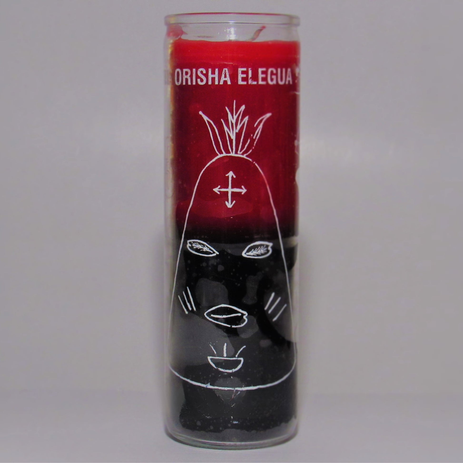 Candle with red top and black bottom, featuring white designs and 'Orisha Elegua