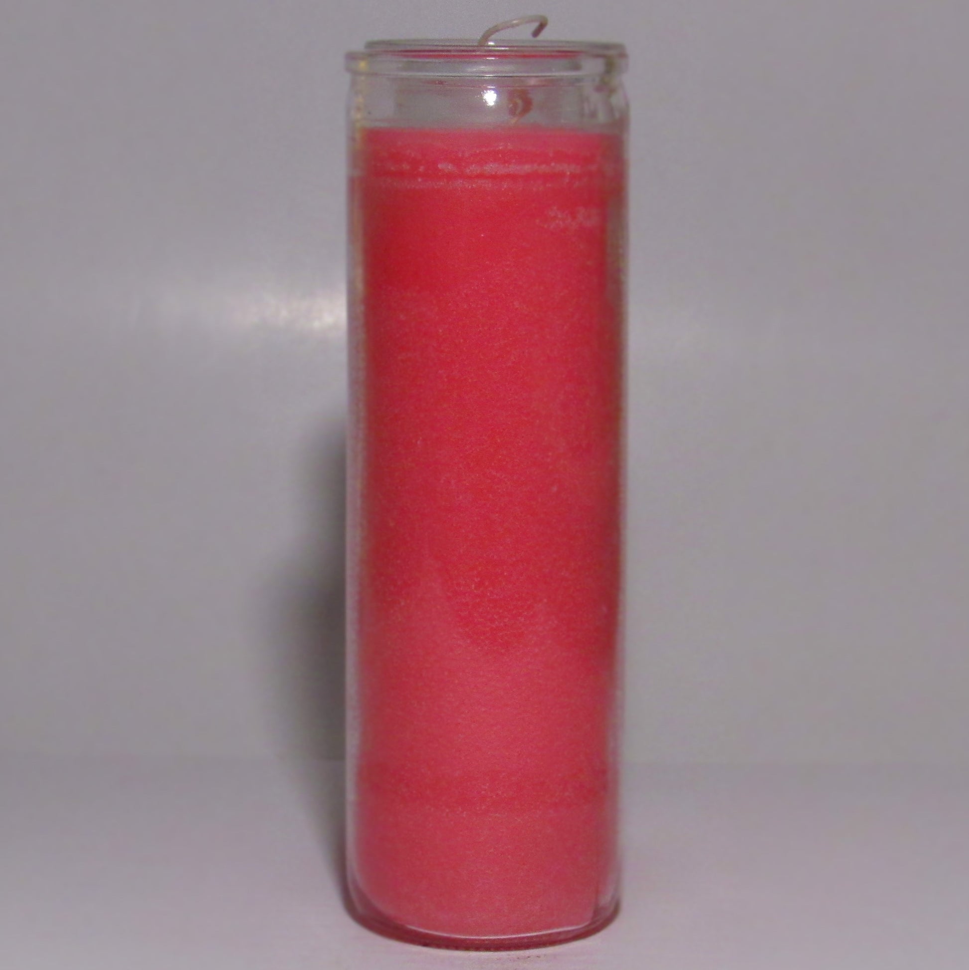 Pink candle in a clear glass holder 