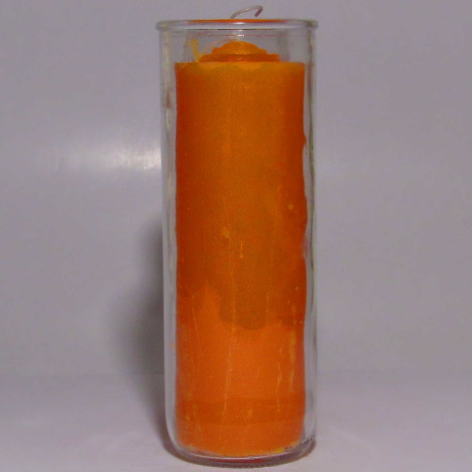 Orange removable wax candle in a clear glass holder 