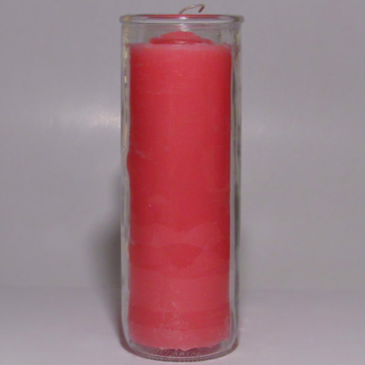 Pink candle inside a clear glass container
