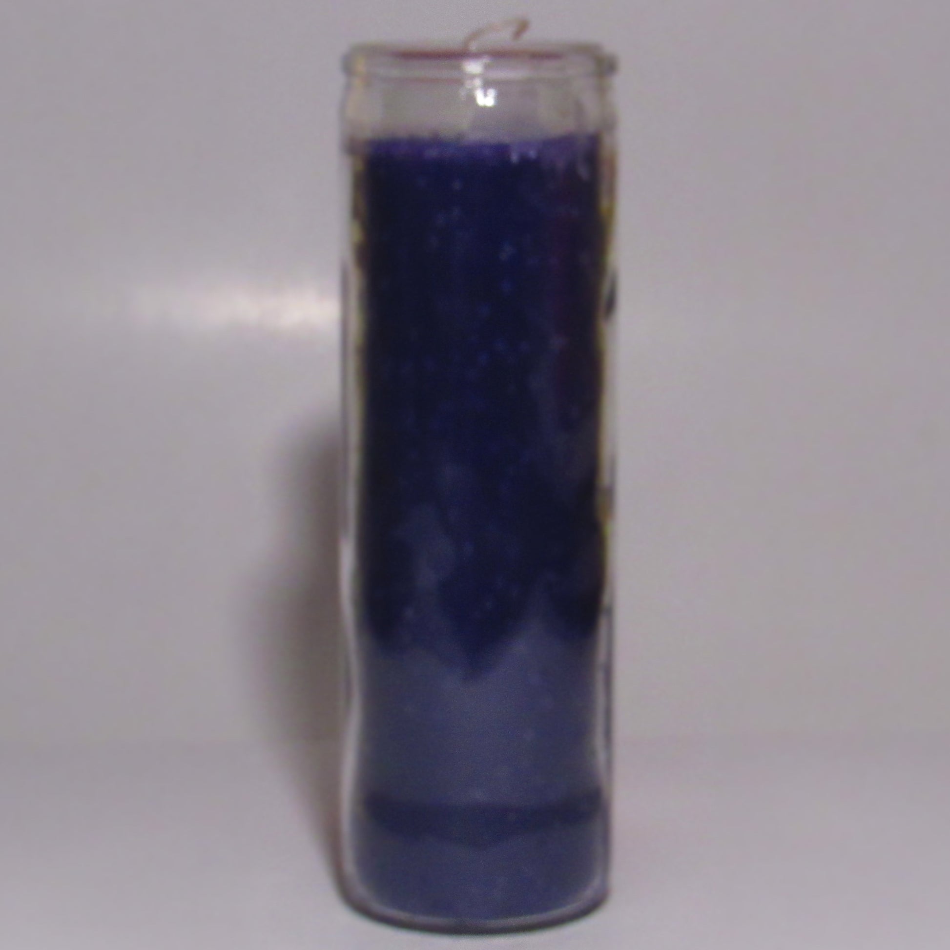 Purple candle in a glass holder 