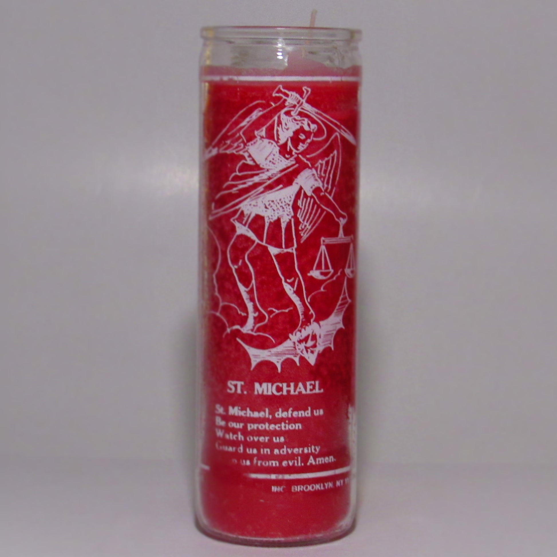 Red candle with white graphics and text 